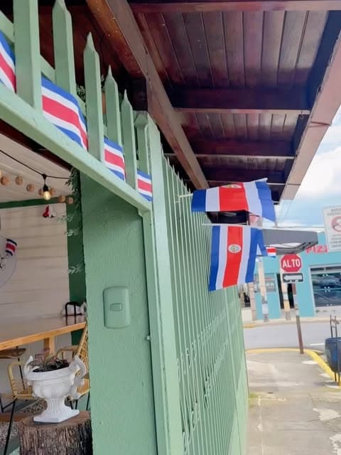 Portón verde menta con banderas de Costa Rica